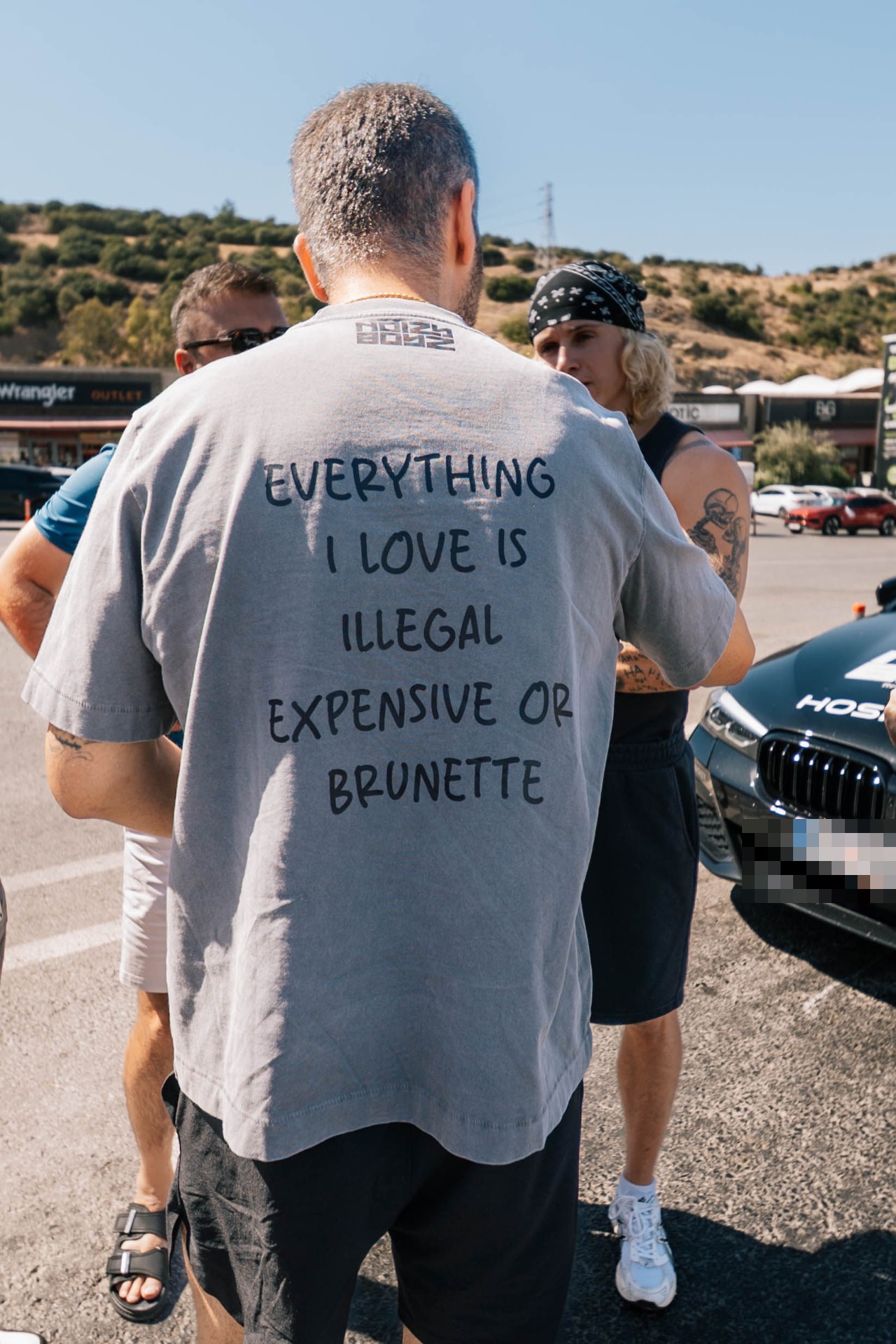 Grey Noizy Boyz shirt reading Everything I love is illegal, expensive or brunette