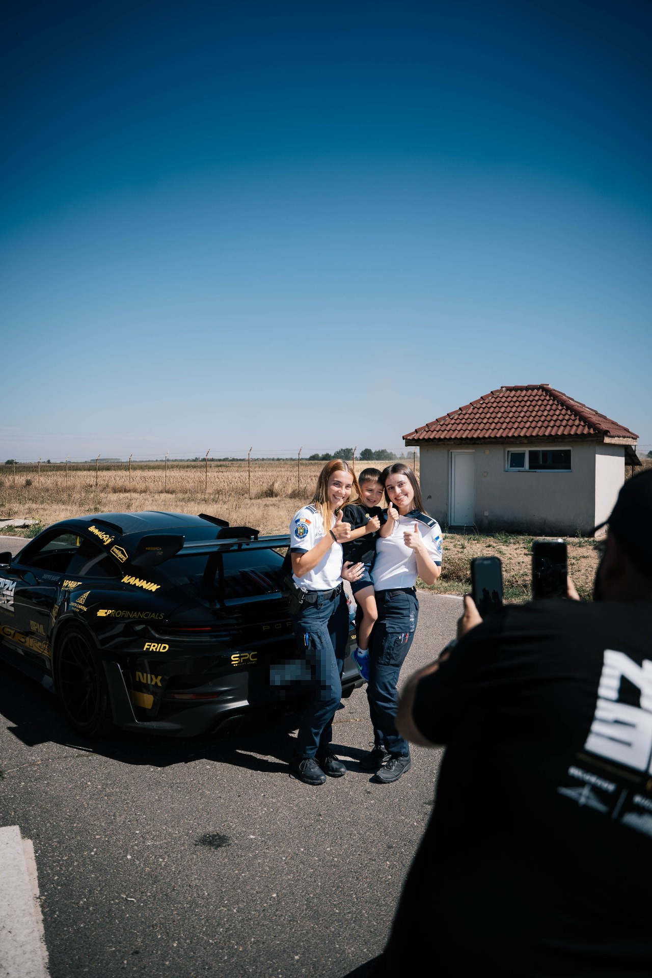 Two border patrol agents posing with the Noizy Boyz GT3 RS