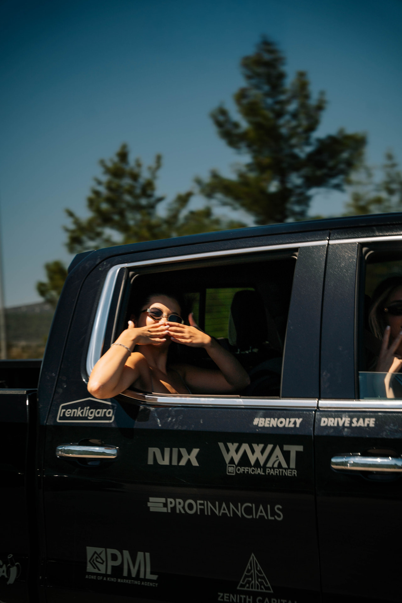 Passengers looking out of the windows of a Noizy Boyz rally truck